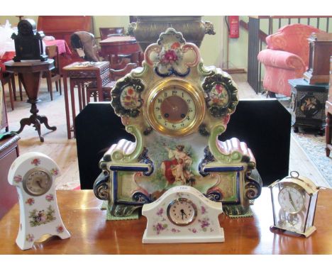 An Edwardian ceramic mantle clock, the shaped case decorated with Bacchanalian figures, enclosing an eight day bell striking 