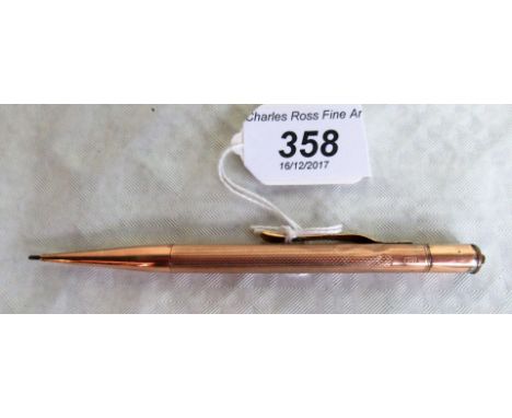 An engine turned propelling pencil, marked 9ct.