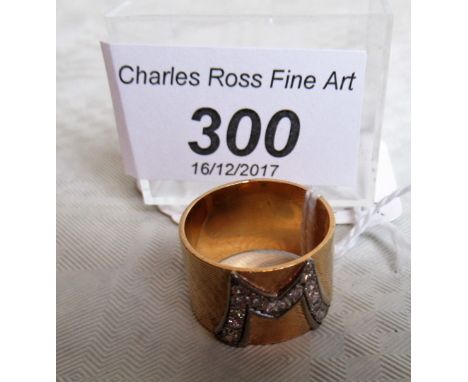 A lady's diamond set monogram ring, the cross matched heavy yellow metal band with applied diamond set monogram.