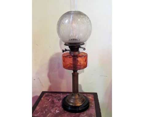 An Edwardian paraffin lamp, having a later opaque shade, amber tinted reservoir, a reeded brass column on stepped circular ce