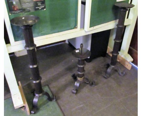 A pair of reproduction floor standing pricket candle stands, together with a similar table lamp.