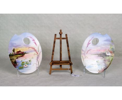 Two small ceramic artist's palettes, each decorated with a river landscape, together with a small giltwood folding easel.