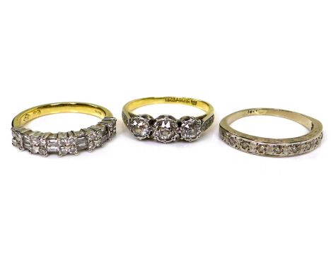 A group of three 18ct yellow gold and diamond rings, comprising a three stone ring, the round cut stones set in platinum, cen