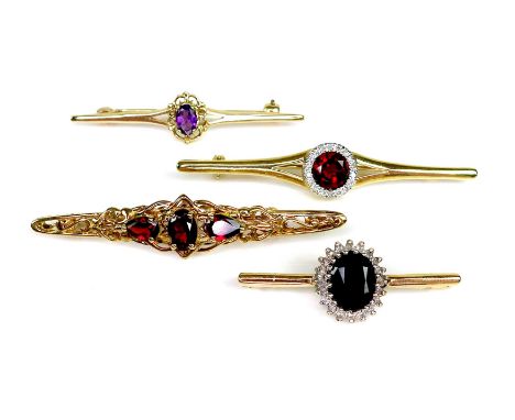 A group of four 9ct gold bar brooches, one set with a round cut dark sapphire, surrounded by diamonds, another with a round c