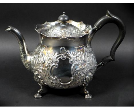 A Victorian silver teapot, repousse decorated with flowers and C scrolls in rococo style, ebonised handle and finial, raised 