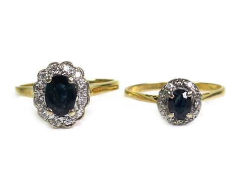 An 18ct gold and sapphire ring, of dark colour and oval cut, approximately 5.5 by 4mm, surrounded by twelve illusion set diam