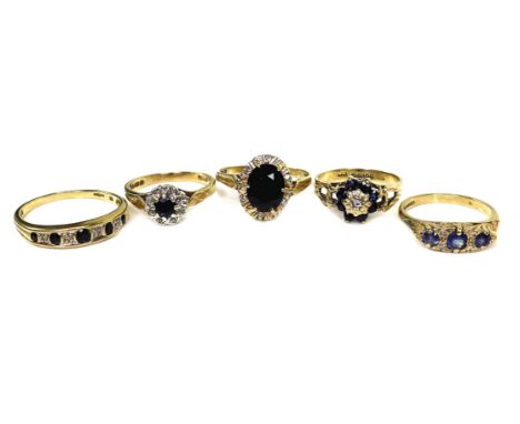 A group of five 9ct gold rings, comprising a 9ct gold and dark stone ring, the stone oval cut and of approximately 9 by 7 by 