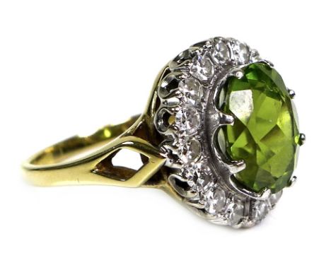 An 18ct yellow gold dress ring, set with an oval cut green coloured stone, likely peridot, approximately 10 by 8 by 6.5mm, su