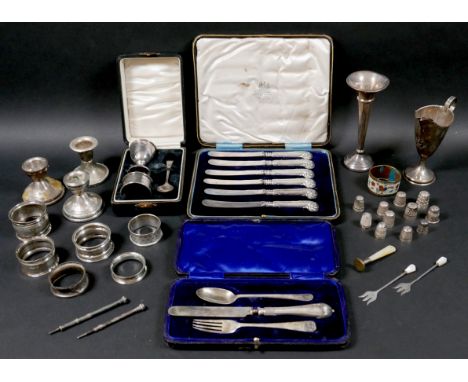 A group of small silver items, including a cased set of six pistol grip butter knives, a cased christening set of knife, fork