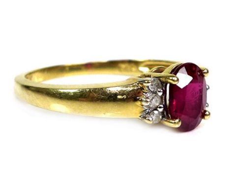 An 18ct gold and ruby ring, the oval cut stone approximately 7 by 5 by 3.5mm, flanked by six 1.5mm diameter diamonds, size P,