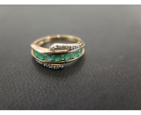 A 9ct gold emerald and diamond crossover style band ring - Hallmarked Birmingham - Ring size O - Weight approx 2.7gms
Conditi