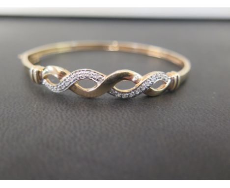 A brilliant-cut diamond twist hinged bangle - Stamped 9K - Inner diameter 6cms - Weight approx 8.4gms
Condition Report: Good