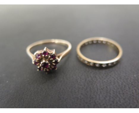 A 9ct gold ruby cluster - Hallmarked London - Ring size R - Together with a white-gem full circle ring - Stamped 9ct - Ring s