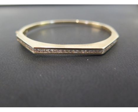 A 9ct gold diamond bangle - Of angular design, the brilliant-cut diamond line within a channel setting - Diamond weight 1.12c