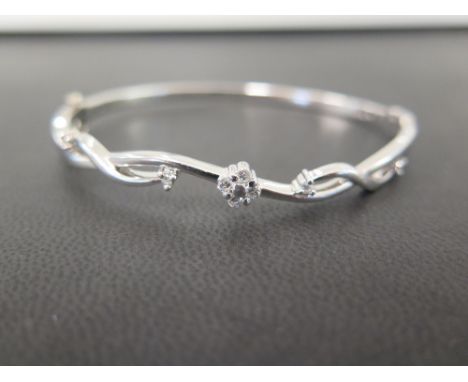 A 9ct gold diamond hinged bangle - Of scroll and foliate design, set with brilliant-cut diamonds - Diamond weight 0.26ct, sta