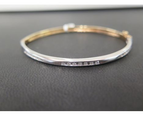A 9ct bi-colour gold diamond bangle - The three brilliant-cut diamond lines to the plain bangle - Hallmarked Birmingham - Inn