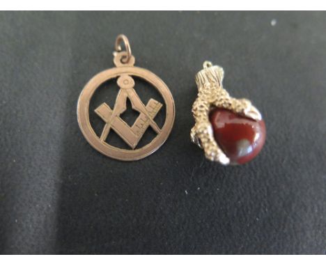 A 9ct gold hardstone bead charm - Held within a bird's claws - Length 2cms - Together with a 9ct gold Masonic charm - Length 