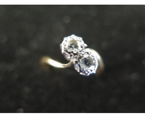 An 18 ct gold crossover two stone diamond ring  - size K - stones approx. 3 mm diameter - Weight approx. 2.8 grms 