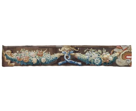 A tapestry fragment, 17th century, worked in polychrome wool thread and showing blossoming flowers amongst ribbons and scroll