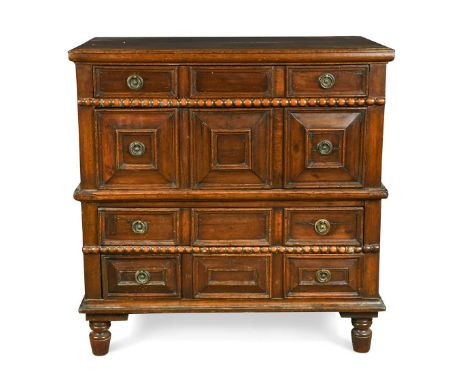An oak and fruitwood panelled chest of drawers, late 17th century, with four long drawers all with fielded panels, ring handl