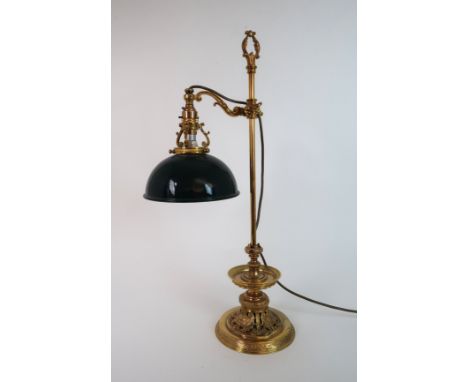 A GILDED METAL DESK LAMP the base with lions heads and swags of flowers, with a green enamel shade, 58cm high Condition Repor