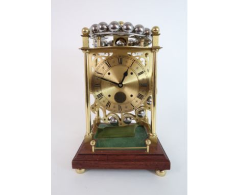 A LATE 20TH CENTURY SPHERICAL WEIGHT CLOCK BY HARDING AND BAZELEY, CHELTENHAM the lacquered brass frame of four columns suppo