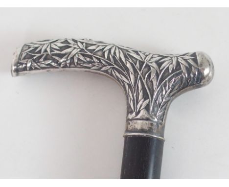 A CHINESE SILVER MOUNTED WALKING CANE cast with a dragon, Shou characters and bamboo, 92cm high Condition Report: Available u