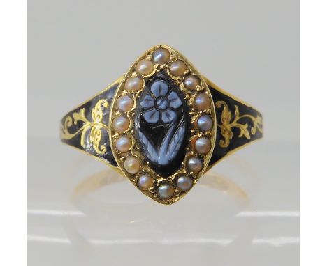 AN 18CT GOLD PEARL AND ENAMEL MOURNING RING with a carved intaglio of a forget-me-not flower set to the centre. Hallmarked Bi