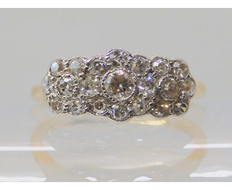 A VINTAGE THREE FLOWER DIAMOND CLUSTER RING set with estimated approx 0.40ctsof old cut diamonds, the bright yellow metal mou