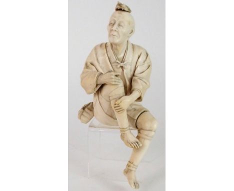 A JAPANESE IVORY OKIMONO OF A FISHERMAN seated and holding a pipe, with a bag tied to his waist, signed, beneath the bag, pro