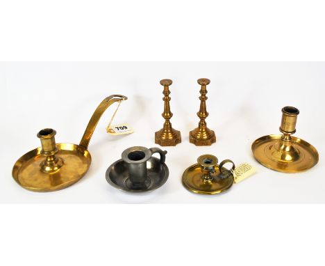 An 18th Century 'frying pan' chamberstick, together with two further chambersticks, a pair of brass candlesticks and a single