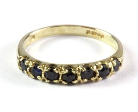 A 9ct yellow gold sapphire set half eternity ring, (M.5).