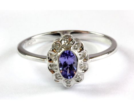 A 9ct white gold tanzanite and diamond set cluster ring, (L.5).