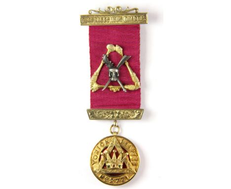 A 9ct gold masonic jewel set with a ruby and two emeralds on a silver gilt ribbon mount.