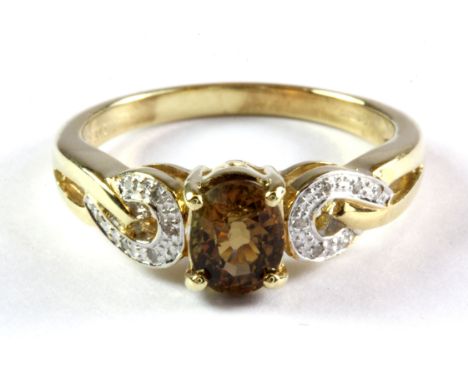 A 9ct yellow gold ring set with a natural oval cut brown tourmaline and diamond set shoulders, (N).