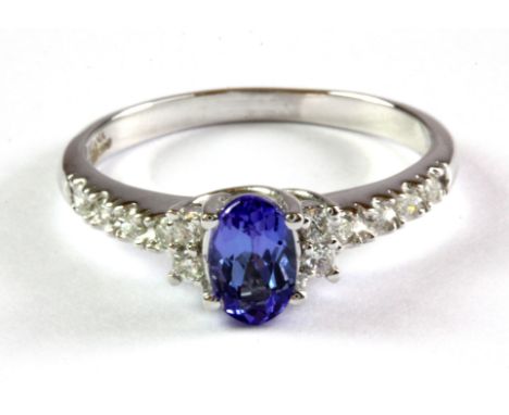 An 18ct white gold tanzanite set ring with diamond set shoulders, (O.5).