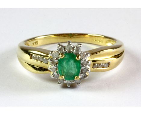 A 9ct yellow gold emerald and diamond set cluster ring with diamond set shoulders, (M.5).