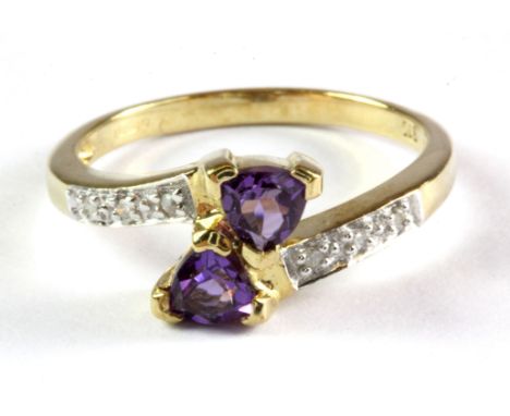 A 9ct yellow gold amethyst and diamond set crossover ring, (L).