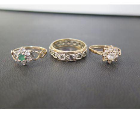 Three 9ct gold gem-set rings - To include an emerald and white-gem cluster, size N 1/2 - A white-gem cluster, size L 1/2 - To