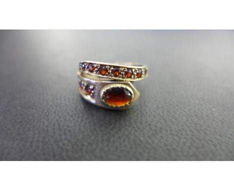 A 9ct gold garnet crossover ring - Hallmarked London - Ring size M - Weight approx 3.9gms
Condition Report: Good - With light