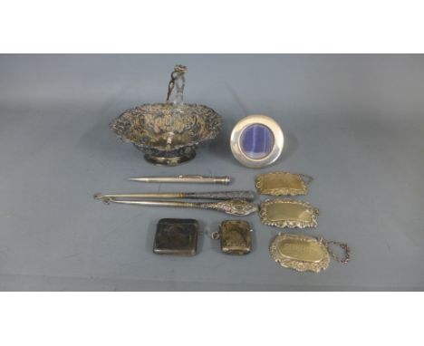 A small circular silver hallmarked picture frame, two silver vesta's, three silver spirit labels, silver propelling pencil, t