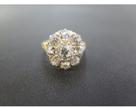 An early 20th century gold old-cut diamond cluster ring - to the carved shoulders and plain half-band - Estimated total diamo