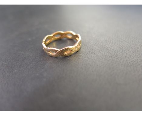 A 22ct gold textured twist ring - Of openwork design with textured detail - Hallmarked London - Ring size L 1/2 - Weight appr