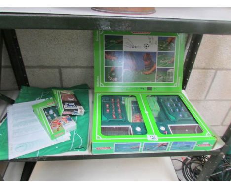 A shelf of Subbuteo items including teams, football pitch etc.,