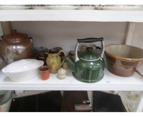 A shelf of vintage kitchen stone ware and enamel ware.