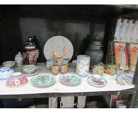 A shelf of assorted oriental porcelain.