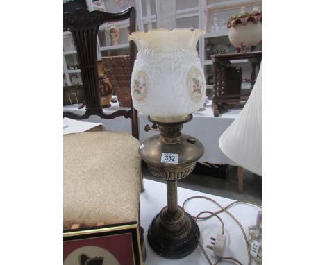 A brass oil lamp with pot base complete with shade and chimney.