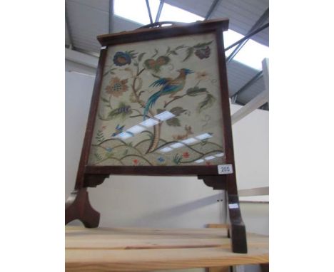 An Edwardian stained wood fire screen with embroidered panel inset.