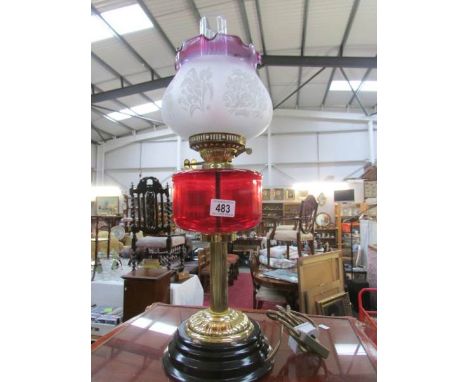 An electric table lamp in the form of an oil lamp with glass font and shade.