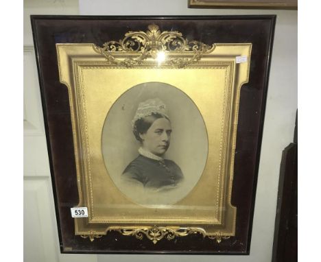 A Victorian gilt framed portrait of an elderly lady in a glass case.